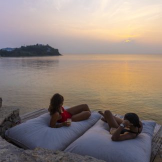 Couple relaxing at sunset in daybeds
